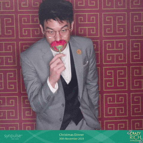 Man in suit at GIF booth with red patterned backdrop