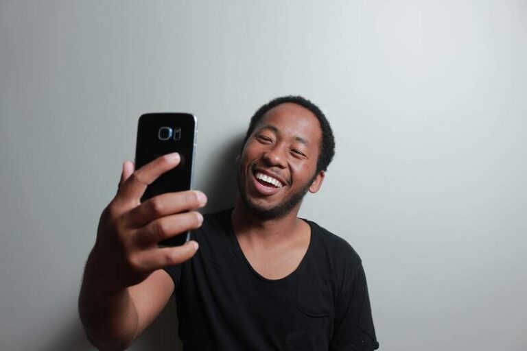 Man taking selfie against white background with virtual photo booth