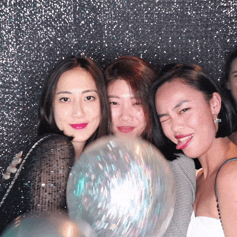 Girls posing at GIF photo booth with party balloon