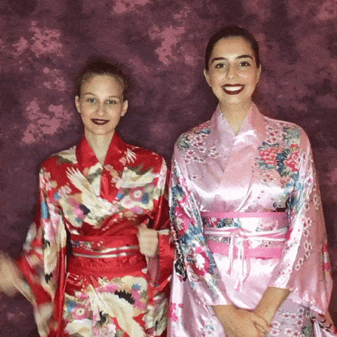 Women dressed in kimonos at GIF booth with red backdrop