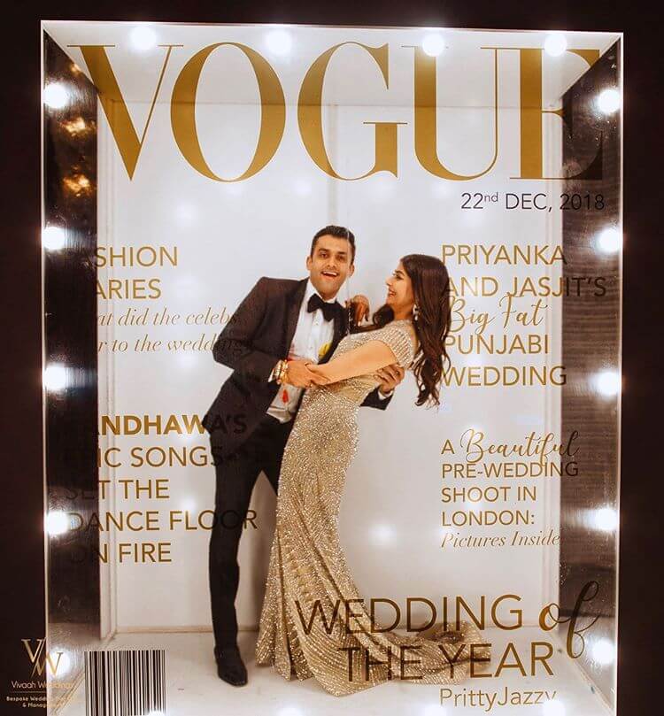 Couple posing in Vogue magazine life-size booth at wedding photoshoot photobooth celebritiy
