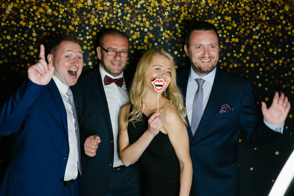 Group of well-dressed friends posing at photo booth