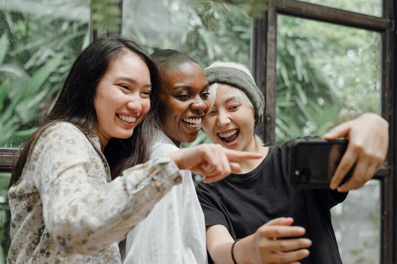 Group of female friends using virtual photo booth