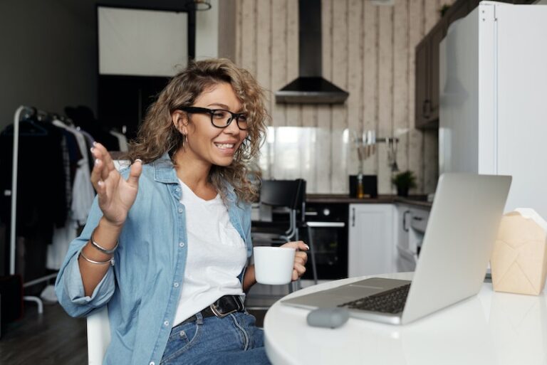 Woman smiling at laptop during a virtual event