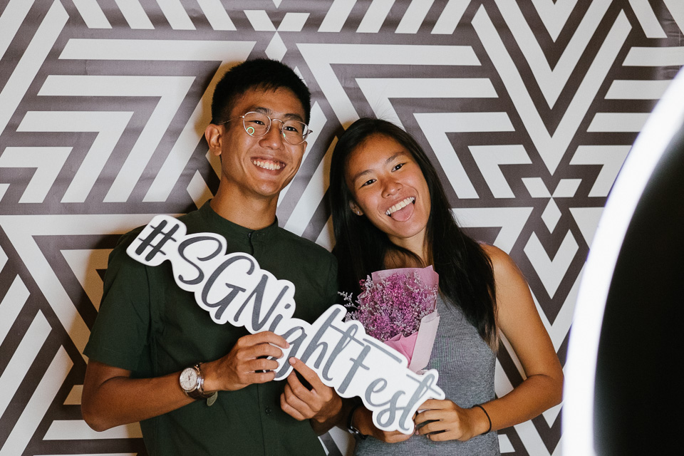Couple holding props and posing at photo booth