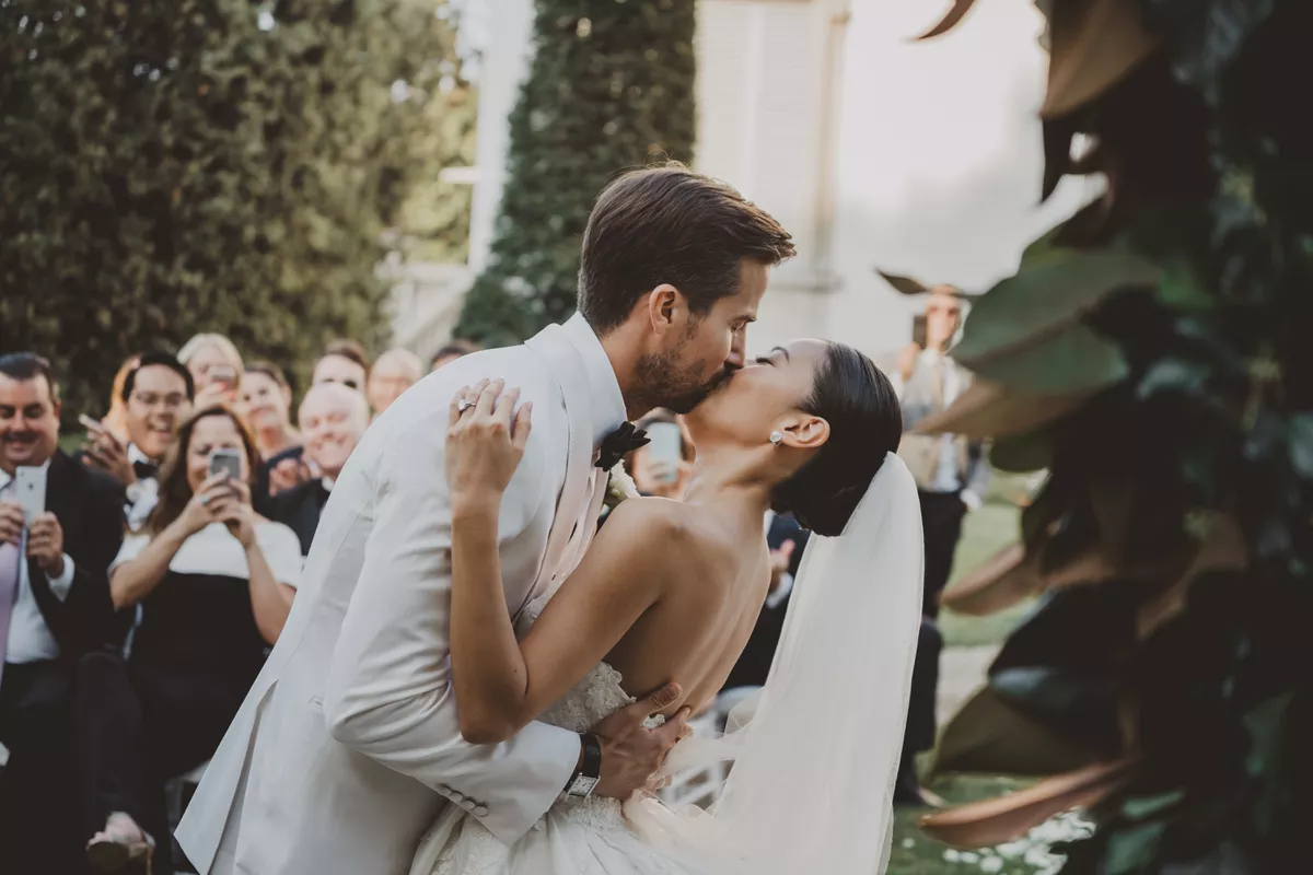 Wedding couple Bride and Groom kiss each other at ceremony celebration by photographer photograph moment