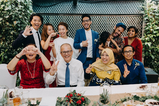 Family having photo together with couple during wedding cohesion photography photograph at wedding venue