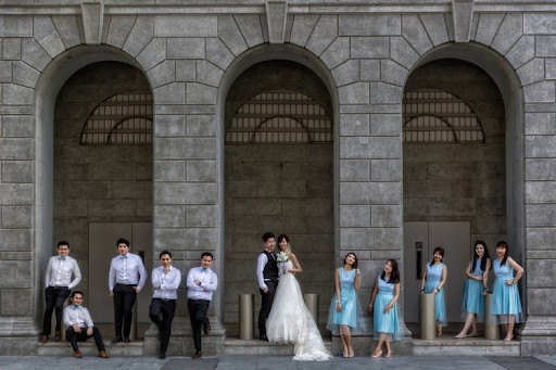 Couple having their photoshoot together outside with groomsmen and bridesmaids outdoor venue photographers and photography event wedding