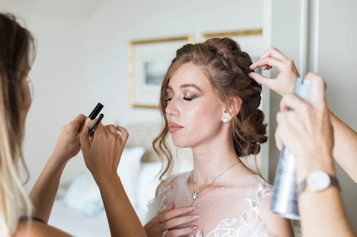 Bride having her makeup being done up by artists before wedding photoshoot