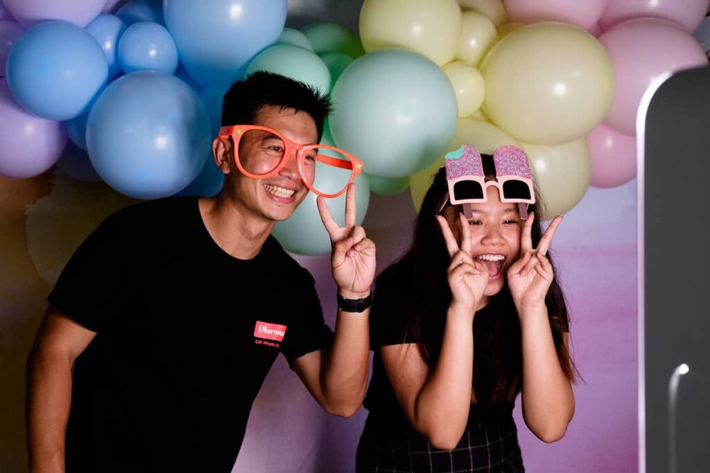Friends pose in front of a balloon backdrop, perfectly lit with studio equipment.